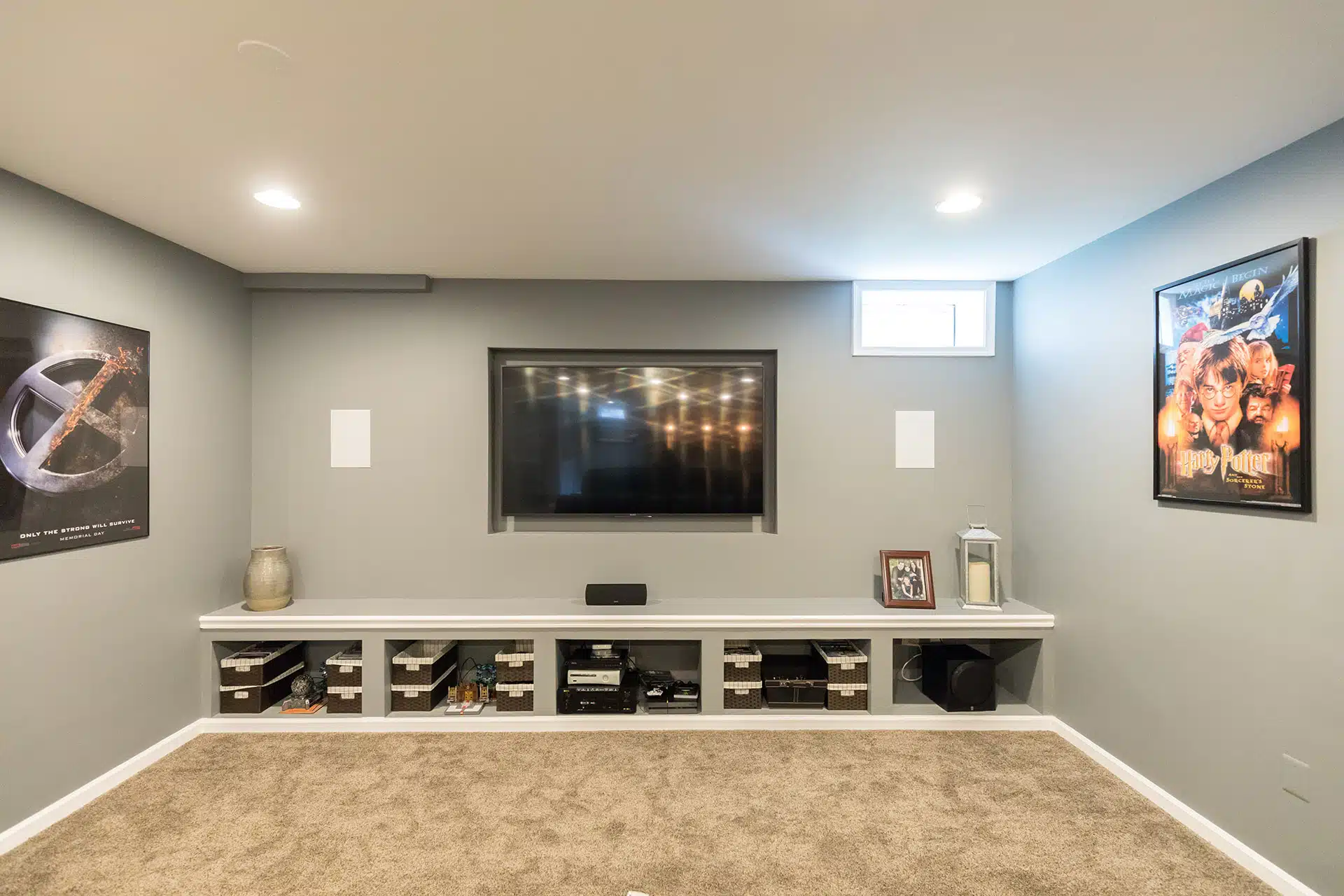 Basement media wall with recessed TV niche and built-in storage by GBC Kitchen & Bath