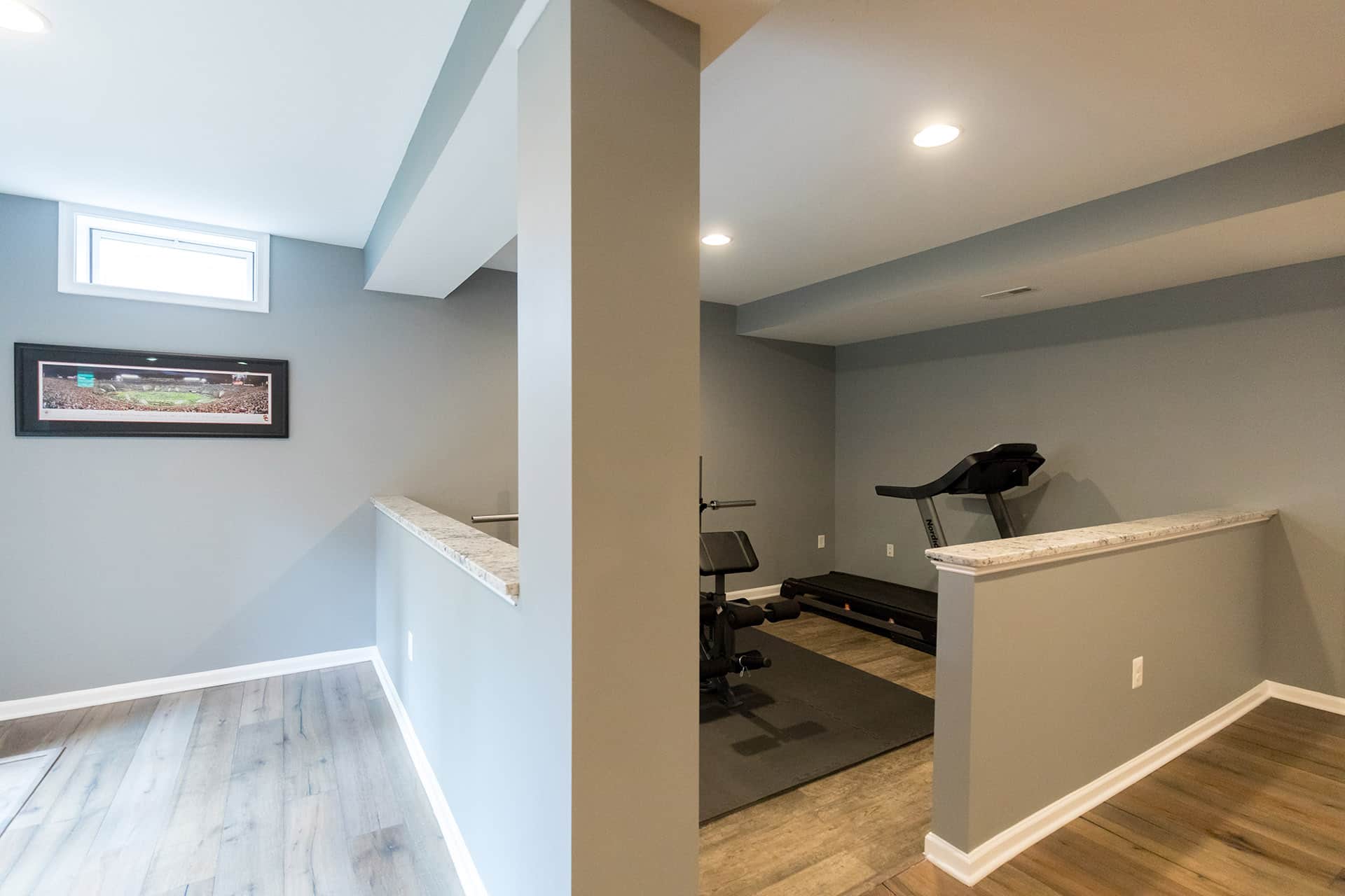 Finished basement home gym with rubber flooring and half walls by GBC Kitchen & Bath