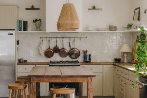 rustic kitchen with hanging copper pans and stainless-steel stove